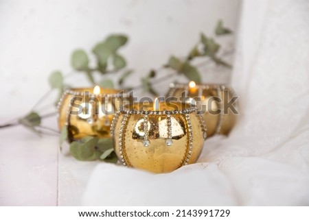 Gold candle holders and eucalyptus leaves