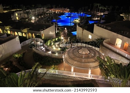 territory of the hotel palm trees swimming pool paths. Night photography. Backlight. Top view. Architecture