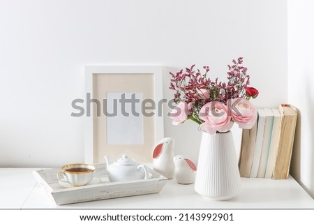 Bouquet of red and pink Persian buttercups on a white table. Scandinavian style. A place for text. Copy space