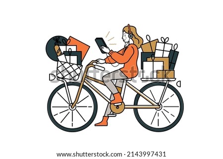 Girl riding a bicycle carrying gifts. She carries in her hand a mobile phone with a navigation system for orientation and listening music.