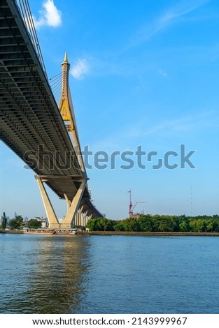 At the mouth of the river in Samut Prakan Province, Thailand, where you can see the cargo ships parked for loading and unloading. and the picture under the bridge that shows how big the river is