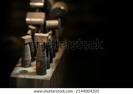 Front view of a set of various tools placed on a wooden desk in a workshop
