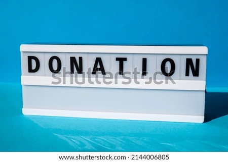 Lightbox with text DONATION. Motivational Words Quotes Concept. Colorful blue background. Minimalistic creative concept. Donation support