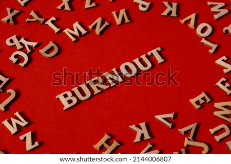 Word BURNOUT made out of wooden letters on bright red background. Motivational Words Quotes Concept. Inspirational phrase
