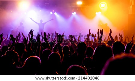 silhouettes of concert crowd in front of bright stage lights Royalty-Free Stock Photo #214402048