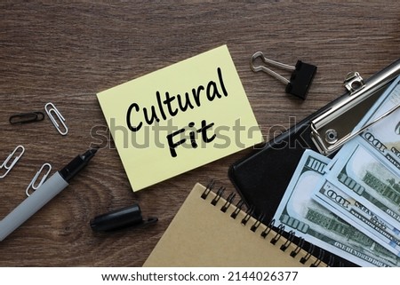 CULTURAL FIT text on yellow sticky note on wooden background