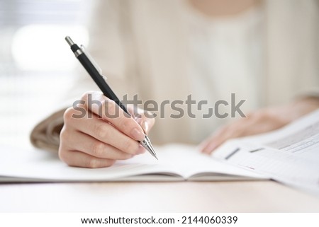 Hands of an Asian woman studying in a coworking space Royalty-Free Stock Photo #2144060339