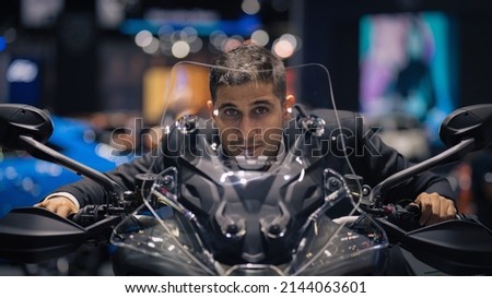 portrait of caucasian man riding on motorcycle in motorshow