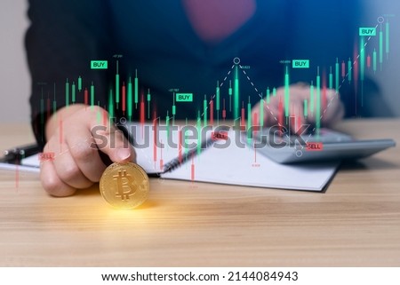 businesswoman finger touching bitcoin coin and is calculating investment income with a calculator on the desk with graph chart. digital. finance, investor, collect money, investment risk