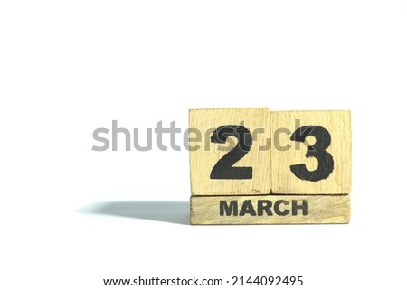 March 23. 23th day of the month, wooden calendar isolated on a white background with shadow.
