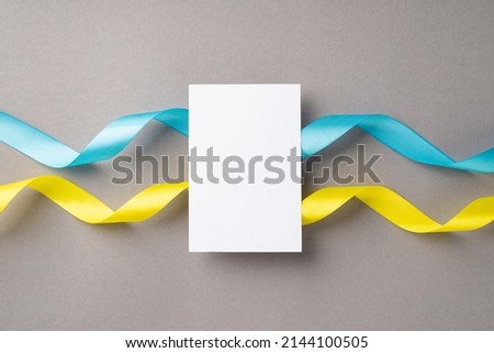 Stop the war in Ukraine concept. Top view photo of paper sheet over national flag on isolated grey background with blank space