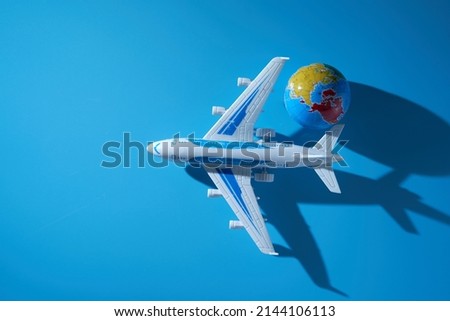 toy airplane and small globe  against blue background