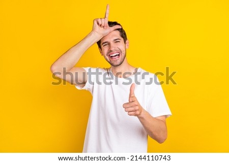 Photo of funky crazy foolish man make horn sign direct finger you wear white t-shirt isolated yellow color background