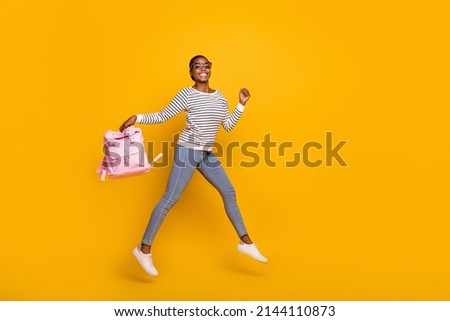 Full body photo of young cheerful lady have fun active jump vacation isolated over yellow color background