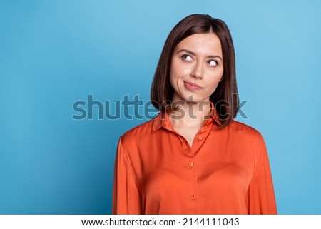 Photo of young pretty woman minded look empty space thoughtful plan isolated over blue color background