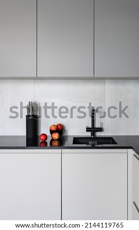Red apples on ablack kitchen counter. Gray kitchen.
