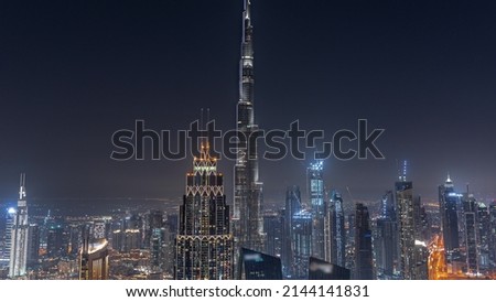 Aerial view of tallest towers in Dubai Downtown skyline with starry sky night timelapse. Financial district and business area in smart urban city. Skyscraper and high-rise buildings