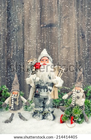 Santa Claus and happy kids in falling snow. Christmas decoration. Vintage style toned picture