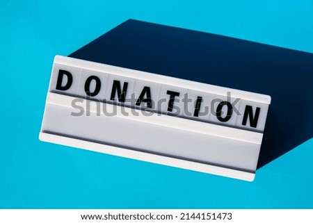 Lightbox with text DONATION. Motivational Words Quotes Concept. Colorful blue background. Minimalistic creative concept. Donation support