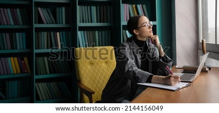 A freelancer woman works in an office, uses the Internet laptop computer workplace coworking space
