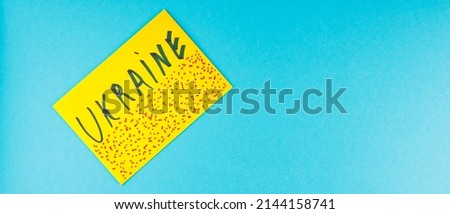 Yellow envelope with the inscription Ukraine on a blue background. Yellow envelope with red spots. Top view. Copy space
