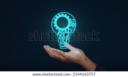Hand with light bulb and there is a gear icon on blue background. Concept of  innovation idea and technology