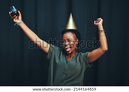 Living my best life. Cropped shot of an attractive young woman dancing alone against a dark background at a New Years party.