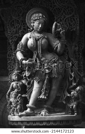 Stone Sculpture of Beautiful Female (Madanikas) with selective focus, 12th century Hindu temple, Ancient stone art and sculptures in each pillars, Chennakeshava Temple, Belur, Karnataka, India. Royalty-Free Stock Photo #2144172123