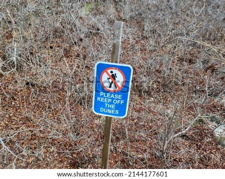 A sign indicating for people to stay off the sand dunes. There is a pictogram indicating that no hiking is allowed.