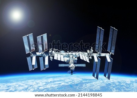 ISS over the planet, against the background of clouds. Elements of this image furnished by NASA. High quality photo