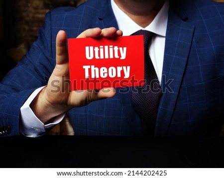 Young man holding a blank card in hands. Conceptual photo about Utility Theory with written text.
