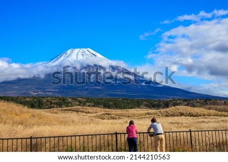 Japan November, 23-2019 Asian tourist man and female standing taking pictures of Mt. Fuji with camera in Japanese landscape view 