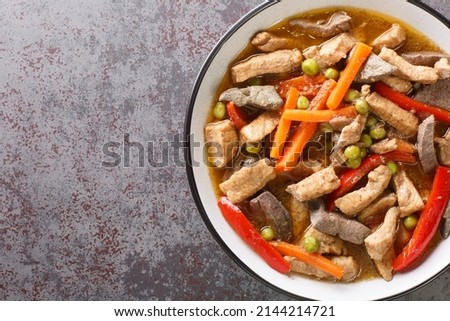 Pork Igado is an Ilocano stew made of strips of liver and pork tenderloin braised in a tangy and savory soy sauce closeup in the plate on the table. Horizontal top view from above
 Royalty-Free Stock Photo #2144214721