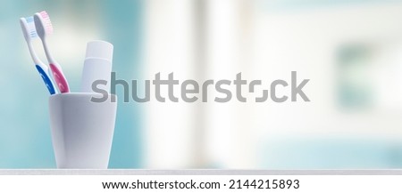 Toothbrush holder with toothbrushes and toothpaste, dental hygiene concept Royalty-Free Stock Photo #2144215893