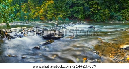 Mountain, rocky river in early autumn. Long exposure photo. Royalty-Free Stock Photo #2144237879