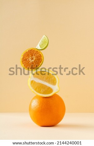 Equilibrium floating food balance. Exotic fruits are floating on the table. Juicy citrus fruits: lemon, lime, tangerine, orange balancing on a yellow background. Royalty-Free Stock Photo #2144240001