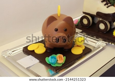 Chocolate figures in the shape of a pig piggy bank. Chocolate pieces to put on top of the Mona de Pascua cake. Typical tradition of the easter holidays in the Spanish and Catalan culture.