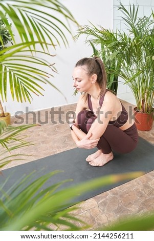 Young woman going yoga table exercise at home. Health care online lessons. Indoor fitness workout. Remote sport trainer. Morning activity. Floor pilates mat. Female person lifestyle. Asana pose Royalty-Free Stock Photo #2144256211