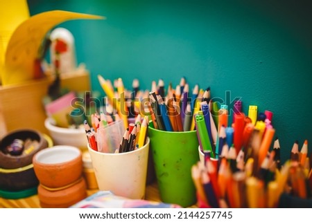 Many colorful feltolsters and pencils in plastic glasses on Drawing classes. Workflow during drawing class lessons in kindergarten 