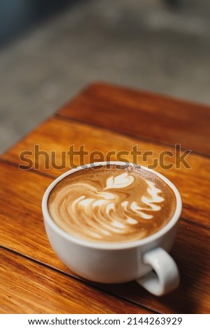 coffee latte art on wood table background  Royalty-Free Stock Photo #2144263929
