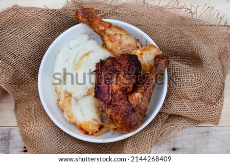 Popular and simple South African Fast food or street food, roasted chicken and pap or maize meal on a rustic surface Royalty-Free Stock Photo #2144268409