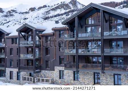 Side view of snowy construction site with new appartment building on the alpine ski resort. Hight quality photo