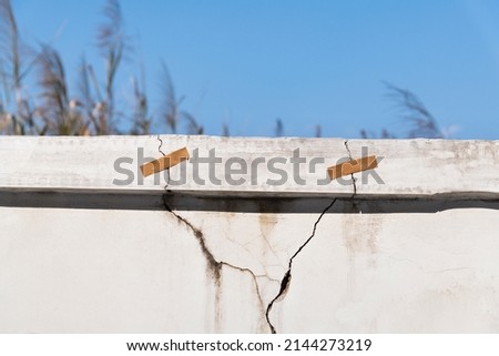 Cracked concrete parapet with adhesive. Royalty-Free Stock Photo #2144273219