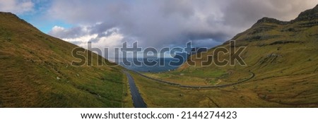 Small village of Trollanes near Kallur lighthouse on Kalsoy island in daytime, Faroe Islands, Denmark. Landscape photography. November 2021. Aerial panoramic view.