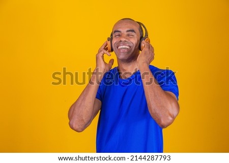 Happy African man smiling listening to music on headphones.
