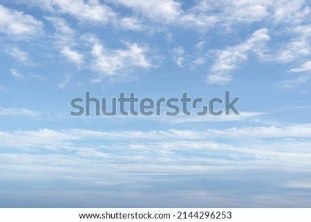 White mixed clouds on summer day. Altocumulus clouds are full of streaks of beautiful, between lower stratus clouds and higher cirrus clouds. Blue sky, no focus Royalty-Free Stock Photo #2144296253