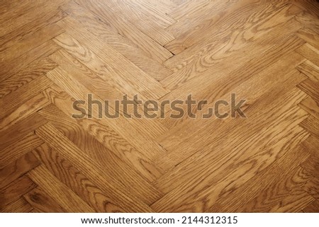 Classic wooden oak parquet in the form of a dark brown Christmas tree. Brown seamless parquet floor with a pattern of spruce from narrow boards. Royalty-Free Stock Photo #2144312315