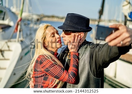 Romantic middle-aged couple taking a selfie at the port