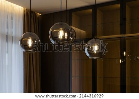 Beautiful retro luxury interior lighting lamp decor. Lamp in the interior. Stylish and modern lamp in loft style in the apartment. Premium Photo. Modern lamp chandelier on a black. Royalty-Free Stock Photo #2144316929