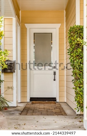 White front door and yellow painted home exterior Royalty-Free Stock Photo #2144339497